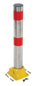 A Vestil Fold-Down Bollard Stainless 4 1/4 In Dia, featuring two red reflective bands near the top, is mounted on a yellow base with four exposed bolts. Nearby, several loose bolts and a key rest on the white background.