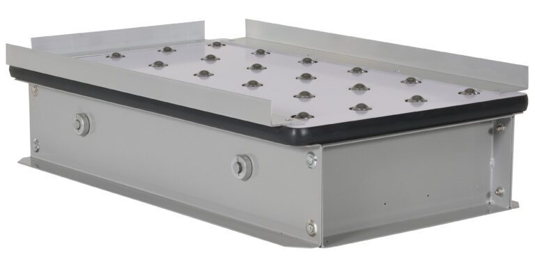 The Vestil Pop-Up Ball Transfer Platform, 19 x 32, is a rectangular gray metal unit with a flat perforated top featuring small domes. It includes side brackets and bolts, making it ideal for mechanical or engineering purposes.