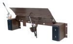 The Vestil Hand Pump Edge-O-Dock Leveler 25K 66X29 is a metal dock leveler with a hinged platform and hydraulic lever, bridging the gap between truck and dock. It features a brown frame, black side bumpers, and visible springs for leveling adjustments.