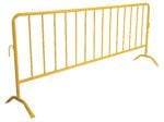 The Vestil Yellow Barrier W/Curved Feet is a stylish crowd control tool with vertical bars and angled legs for stability. It has a hook on one side for easy connection of multiple barriers, against a white background.