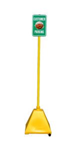 The Vestil Yellow Pyramid Sign Base W/Pole & Wheels includes a green Customer Parking sign with red and white text plus a logo. A square base provides stability, wheels ensure easy movement, and its set against a white background.