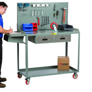 A person in a blue and white shirt writes on a clipboard at a gray Little Giant Work Height Mobile Workstation, with tools, a hammer, two blue bins on the bench, and a cardboard box on the lower shelf above two drawers.