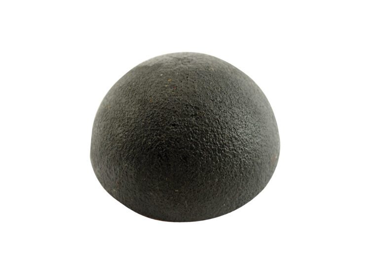 A half black truffle, with a rough texture and smooth dome shape, is displayed against a white background, echoing the natural elegance of Vestil Rounded Rubber Dome Bumpers 2 x 2 in.