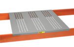 The Little Giant Perforated Steel Rack Decking has a perforated steel panel with three columns of round holes on two parallel orange beams. An industrial-style yellow label with bold black and red text is affixed to the panel.