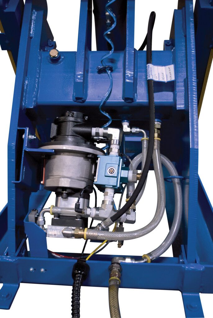 A close-up of a mechanical apparatus with interconnected metal components, featuring the Vestil LLH Rotary Air/Oil Handheld Push-Button, hoses, and a motor in a blue frame. Various pipes and cables are visible, indicating complex engineering with rotary functionality and handheld controls.