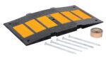 The Vestil Middle Section Asphalt Kit 35.25 includes a black rubber speed bump with five yellow reflective strips, adhesive tape, and five long metal screws for easy installation, enhancing safety and visibility on roadways.