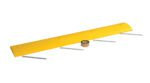 A yellow Vestil Speed Bump-Asphalt Hardware 72X12X2.25 featuring five metal spikes underneath is positioned beside a roll of tan duct tape on a white background.