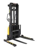 The Vestil Hand Pump/Dc Stacker 118 In Adj Fork/Leg, set against a plain white background, features two adjustable forks and a hand pump for easy operation. Its yellow and black design with safety labels enhances lifting task efficiency.