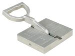 Image of a large metal tag punch tool with a rectangular base and angled handle, similar to the sturdy design of the Vestil Sheet Handler 125 Lb Working Capacity. Its engraved surface markings enable it to emboss letters or numbers onto metal tags efficiently.
