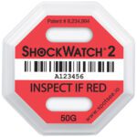 The 50G Shockwatch® 2 Indicator has a barcode, serial number A123456, and text INSPECT IF RED and 50G. With Patent #8,234,994, it features a white backdrop with red and black accents. More details at www.spotsee.io.