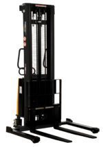 The Vestil Adjustable Stacker W/Powered Lift 137 In has a black hydraulic forklift stacker with a vertical lift, two-pronged forks at the base, and safety warnings on the side, displayed freestanding against a white background.