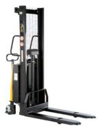 The Vestil Fixed Stacker W/Powered Lift 63 In has a yellow and black design with handles, a hydraulic lift system, extended forks, safety signs, and a grated protective guard. Its ideal for efficiently moving and stacking pallets in warehouses.