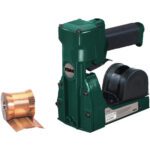 An ISM green industrial stapler with a black handle stands upright beside copper-colored staples, highlighting the brand on its body. Its robust design rivals the functionality and durability of an MH-USA 3/4 Pneumatic Roll Feed Carton Stapler.