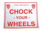 The Vestil Vinyl Wheel Chock Sticker (11-3/4 x 9-3/4) displays THE LAW SAYS CHOCK YOUR WHEELS in bold red on white, with OSHA logos in the top corners.
