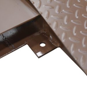 Close-up of a corner of a textured, brown metal object with a small hole on a flat piece for potential mounting, similar to the versatile Vestil Anchor Brackets (4 Per Riser), showing metallic reflections and shadows.