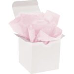 A white gift box with an open lid is filled with MH-USA 20 x 30 Light Pink Gift Grade Tissue Paper, capturing its soft hue. The scene rests serenely against a plain white background.