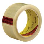 A 2 x 55 yds. Clear 3M™ 373+ Carton Sealing Tape with a red plaid pattern on one end and a yellow core featuring Scotch printed inside stands upright, highlighting its thickness and texture against a plain background.
