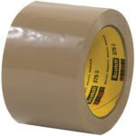 A shiny beige roll of 3 x 55 yds. Tan Scotch® Box Sealing Tape 375 is partly unrolled, showing its adhesive side and a yellow label with the brand logo and details, all conveniently packed in a case of 24.