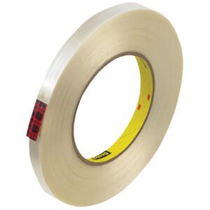 The 1/2 x 60 yds. (12 Pack) Scotch® Filament Tape 890MSR is clear tape with a durable design, featuring a red and black plaid inner core section and yellow areas with small text. Its neatly wound for hassle-free use.