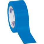 A partially unrolled 2 x 36 yds. Blue Tape Logic® Solid Vinyl Safety Tape reveals its smooth surface, with a branded inner ring contrasting the bold blue against a white backdrop, available in a convenient 3 Pack.