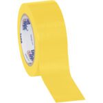 A roll of 2 x 36 yds. Yellow Tape Logic® Solid Vinyl Safety Tape (24/Case) is partially unrolled, showcasing its glossy bright yellow surface and the brand name on the inner cardboard ring.