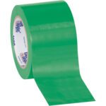 A roll of 3 x 36 yds. green adhesive tape from the Tape Logic® Solid Vinyl Safety Tape collection is slightly unrolled, revealing its glossy surface, with the inner ring branded in blue and red. This (3 Pack) set combines style and reliability.