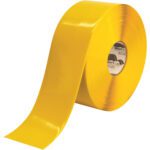 The 4 x 100 Yellow Mighty Line™ Deluxe Safety Tape (1 Roll/Case) features a wide, flat surface with vibrant color, a smooth texture, and printed text on the inner core.