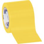 Partially unrolled, a wide bright yellow roll of 4 x 36 yds. Tape Logic® Solid Vinyl Safety Tape with a shiny surface and an inner core printed in blue text on white comes in cases containing 12 rolls.