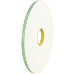 A large roll of 1/2 x 18 yds 3M Double Sided Foam Tape 4004, featuring a green checkered adhesive pattern, stands upright. The thick white-sided roll has a visible yellow core and is available in a case of 18 for versatile use.