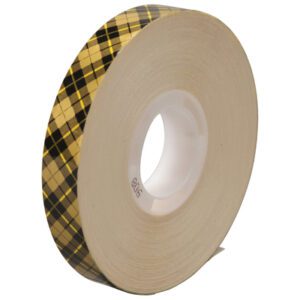 The 1/2 x 36 yds. 3M™ 908 Adhesive Transfer Tape, with a white core and gold/black argyle pattern, stands upright against a plain white background. There are 72 stylish rolls per case.
