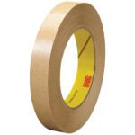 A roll of 3/4 x 60 yds. brown paper masking tape, part of the versatile 3M™ 465 Adhesive Transfer Tape Hand Rolls (6 Pack), stands upright with the iconic 3M logo on its yellow core.