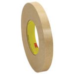 A roll of beige 3/4 x 120 yds. 3M™ 9498 Adhesive Transfer Tape with its yellow core and red-white logo stands upright, angled to display its width and thickness, against a white background.