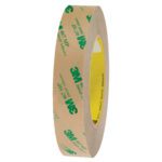 A side view of the 1 x 60 yds. (6 Pack) 3M™ 467MP Adhesive Transfer Tape Hand Rolls featuring tan paper backing with green logo for easy application.