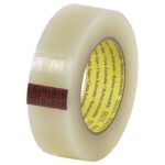 The 1 1/2 x 60 yds. Scotch® Stretchable Tape, with its plaid-patterned label and smooth glossy finish, stands upright. Inside, a yellow label with text is visible—ideal for versatile sealing solutions.