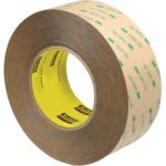 The 2 x 60 yds. (2 Pack) 3M™ 9472LE Adhesive Transfer Tape Hand Rolls features a brown tape with a yellow core and green text/logos, matching the dimensions of the product name and offered in a convenient two per case package.