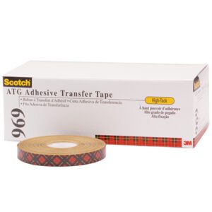 A roll of 1/4 x 18 yds. 3M™ 969 Adhesive Transfer Tape (72 Rolls/Case) is displayed with its sleek white box featuring black text and product number 969. The tapes side shows off a distinctive plaid pattern.