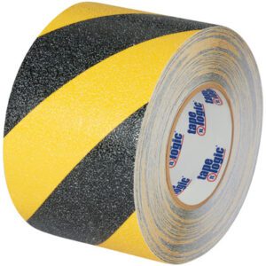 The 4 x 60 Black/Yellow Striped Heavy-Duty Tape Logic® Anti-Slip Tape has bold diagonal stripes and a textured surface, complemented by a white label with blue and red text, offering both practicality and visual appeal.