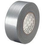 A roll of 1 x 60 yds. Silver 3M™ 3939 Duct Tape, part of a 36 Rolls/Case set, is partially unrolled to show its adhesive side, resting against a white background with a shiny, textured surface and multilingual text on the cardboard core.