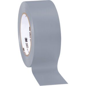 A 2 x 50 yds. Gray (3 Pack) of 3M Vinyl Duct Tape 3903 unfurls, displaying its matte yet subtly reflective surface and a text-adorned inner cardboard core, making it a versatile tool for many tasks.