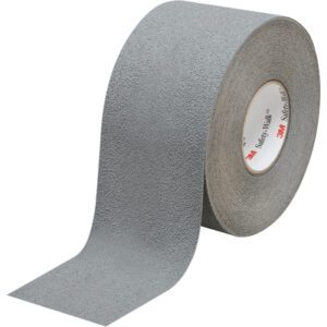 A 4 x 60 roll of Gray 3M™ Safety-Walk™ Tape - 370, partly unrolled, displays its textured surface. Upright, it shows the inner cardboard core with a small red logo inside.