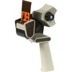 Introducing the 3M™ H180 2 Industrial Carton Sealing Tape Dispenser—a beige and brown tool featuring a ridged grip handle, circular tape holder, and sharp metal cutter. With its orange safety label, it combines precision with safety for every task.