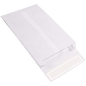 A 10 x 13 x 2 white expandable Tyvek® envelope from the 10 x 13 x 2 White Expandable Tyvek® Envelopes (100/Case) sits on a surface, flap open to show an adhesive strip. Viewed at an angle, it promises durability and ample space.