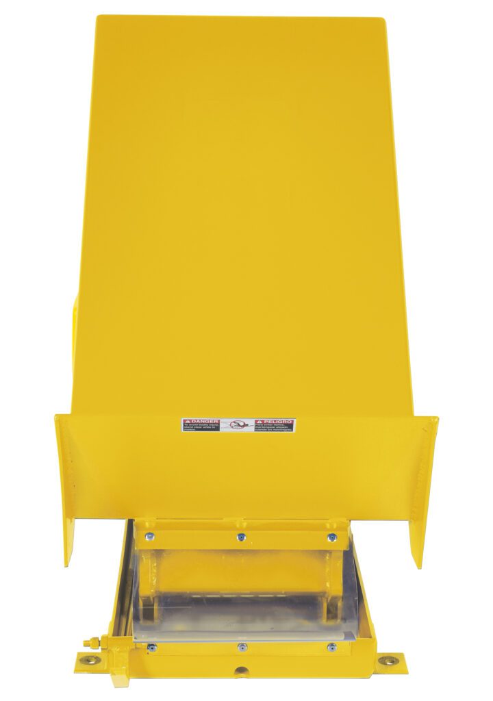 The Vestil Lift Table 2K 24X48 in yellow has a slanted top, flat base, and chute, with caution labels. This sturdy metallic equipment operates on 230V, 3-phase power and stands against a white background, emphasizing its industrial design.