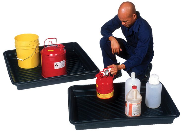 Kneeling in a dark blue outfit, a person is beside a black Vestil Utility Tray 52.25 X 28.25 24 Gal, holding a red canister, beige jug, and white bottle. Nearby, another tray holds a yellow bucket and a red canister with a yellow lid.