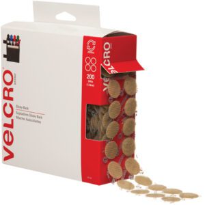 A box of 3/4 beige VELCRO® Brand dots with one side open reveals a roll of circular fasteners. The predominantly white and red packaging showcases the logo and details, making it ideal for combo packs (200/Case).