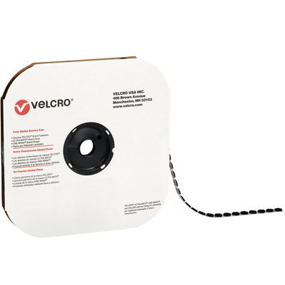 VEL126.jpg A roll of 3/4 black VELCRO® Brand hook-and-loop tape is unwound, sitting in a square dispenser with a central circular spool. Its white packaging features the Velcro logo and details, offering individual dots (1028/case) for versatile use.
