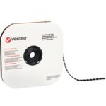 A spool of 7/8 Black VELCRO® Brand Tape, featuring individual dots, sits on a cardboard holder partially unraveled. The Velcro logo and company address are printed on the cardboard.