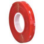A red tape roll, featuring 3M VHB print, is wound around a white core at an angle. Its striking color and iconic branding resemble the 1 x 5 yds. Clear 3M™ 4910 VHB™ Tape (1 Roll/Case).