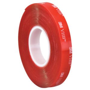 A red tape roll, featuring 3M VHB print, is wound around a white core at an angle. Its striking color and iconic branding resemble the 1 x 5 yds. Clear 3M™ 4910 VHB™ Tape (1 Roll/Case).