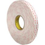 The 1 x 5 yds. White 3M™ 4955 VHB™ Tape comes in a large roll with a white look, iconic red branding on a yellow spool, and is showcased upright to highlight its thickness and durability.